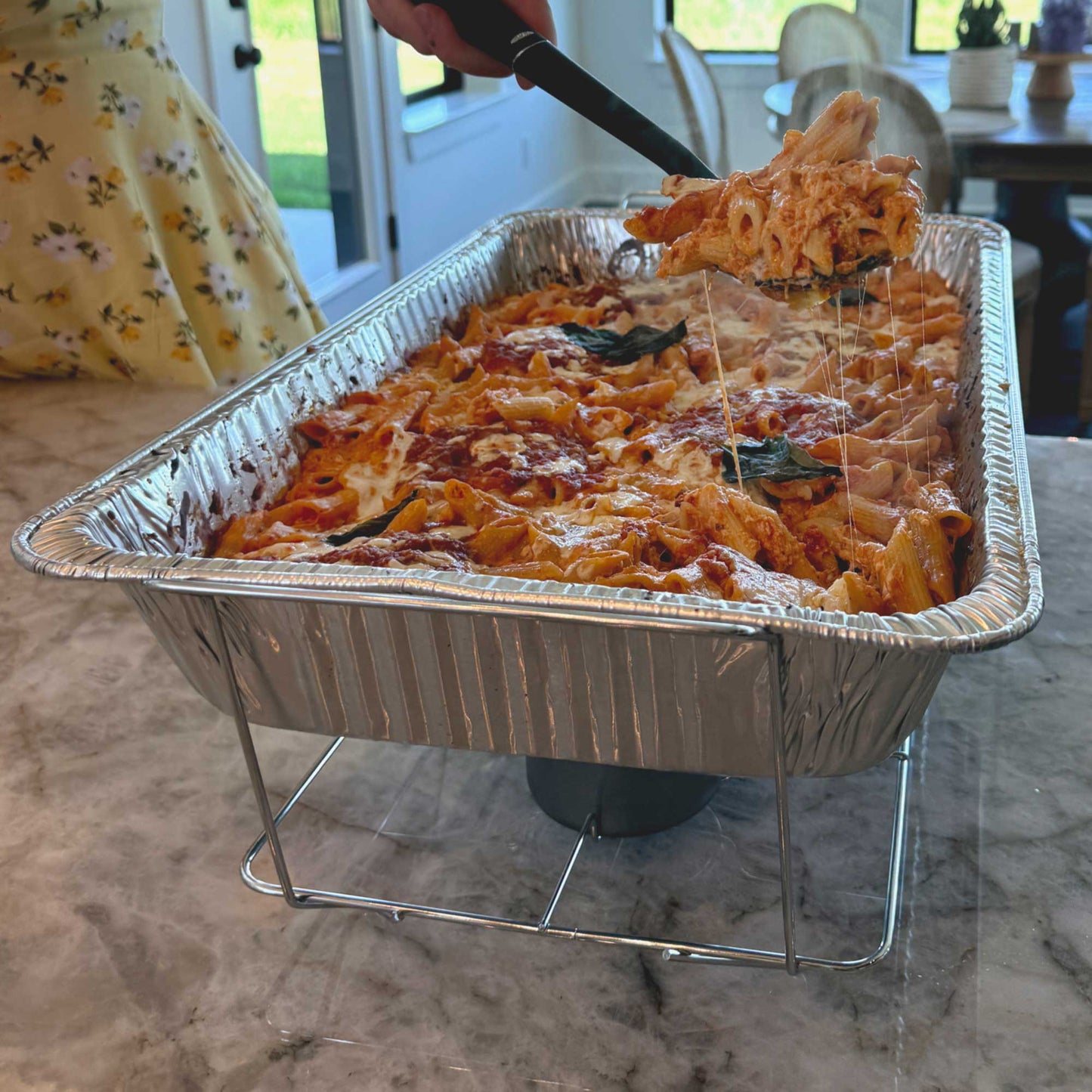 Professional wire chafing rack holding full-size aluminum pan filled with delicious, hot baked ziti – R&S Services