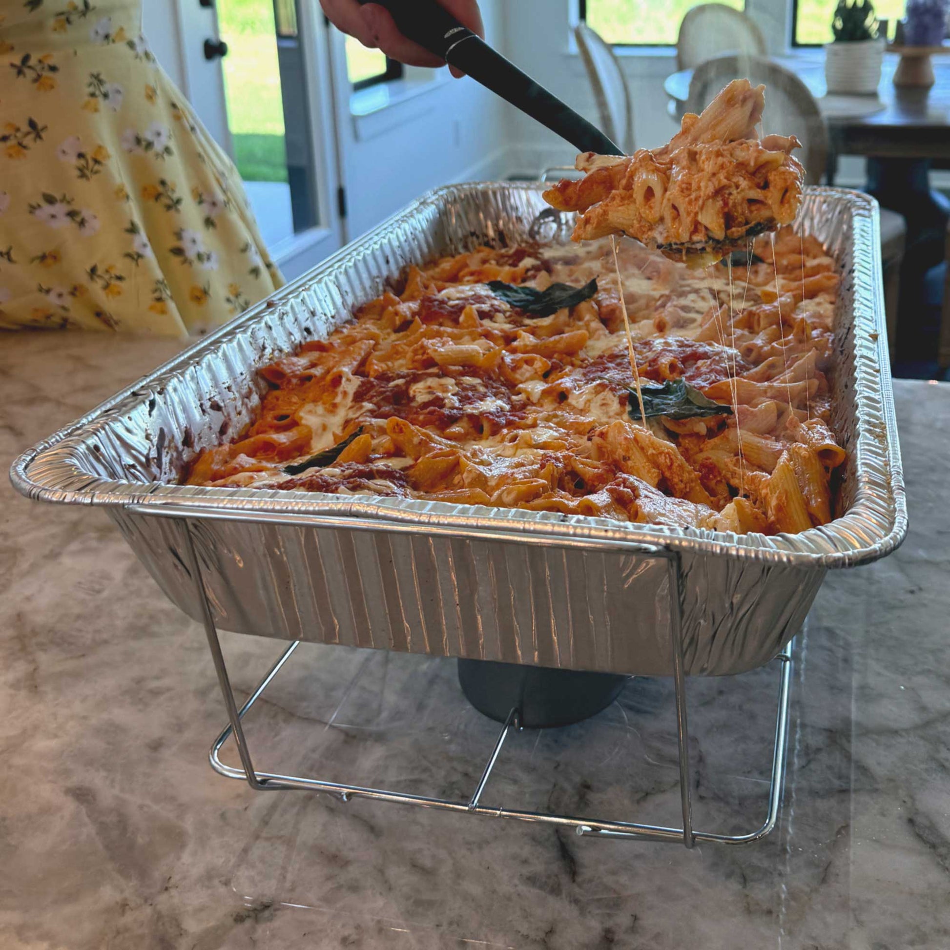 Professional wire chafing rack holding full-size aluminum pan filled with delicious, hot baked ziti – R&S Services